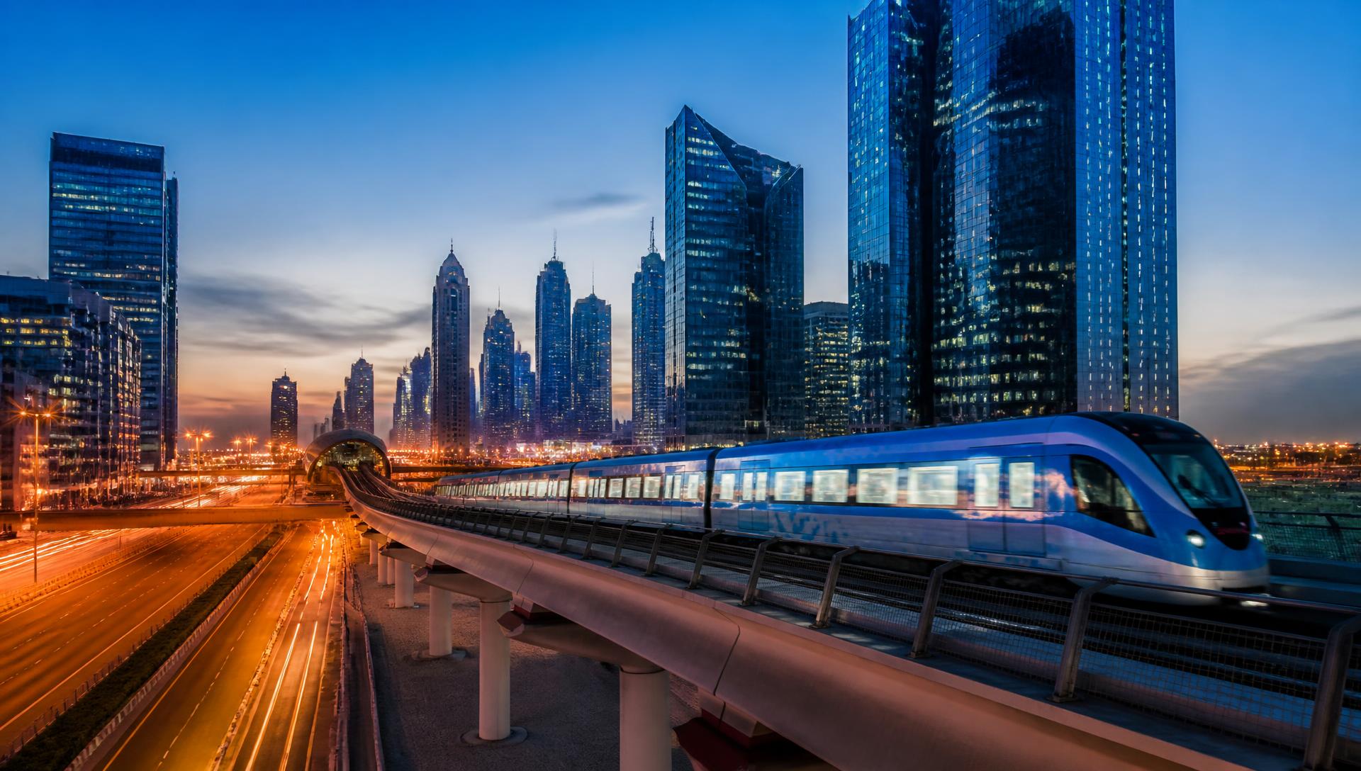 Elevated metro corridor and modern glass office towers in a metropolitan skyline at dusk